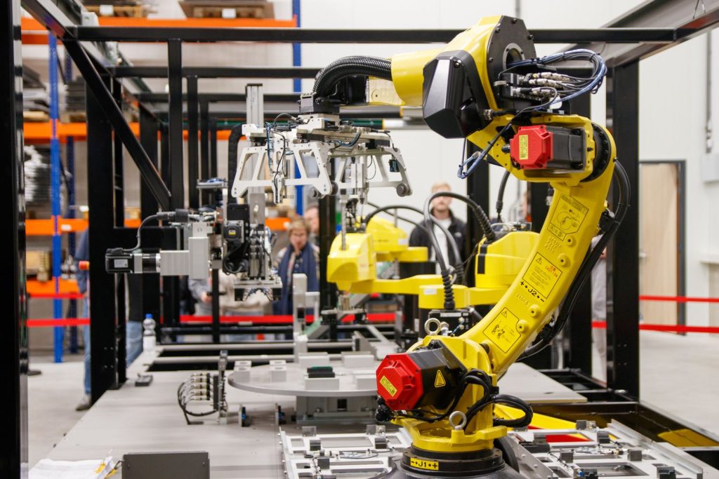 Sárga ipari robotkar egy modern gyártócellában